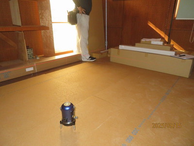 レーザーレベルを床の中央に設置して、部屋の四隅の高さを測定する。