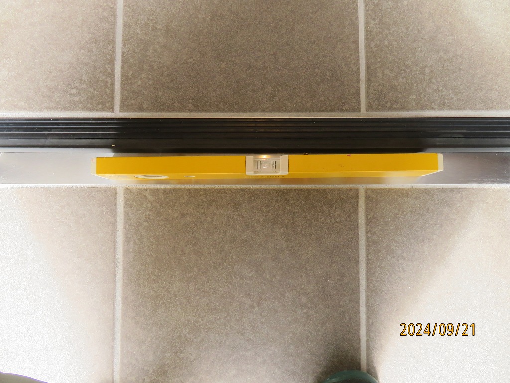 玄関扉敷居が水平に取り付けされているか、水平器を置いてチェックします。